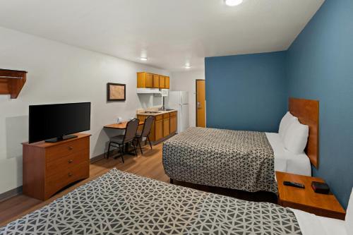 埃尔帕索WoodSpring Suites El Paso的酒店客房设有两张床和电视。