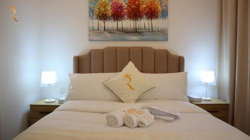 阿布扎比Glen 2BR Duplex Masdar city的一间卧室配有一张床,上面有两条毛巾