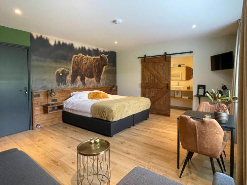 Loon op ZandHotel B&B Buiten Loon的卧室配有一张床,墙上挂着牛油画