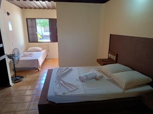 圣安娜-利弗拉门图Hotel Comodoro De Livramento的一间卧室配有两张床和风扇