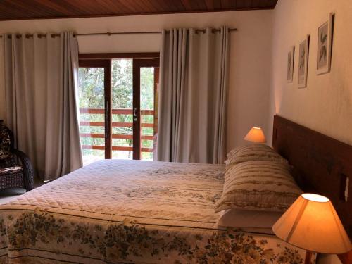 多明戈斯马丁斯Villa Uliana - Bangalôs VILLA的一间卧室设有一张大床和一个窗户。