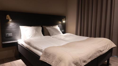 霍尔斯特布罗Hotel Nørreport的卧室配有一张带白色床单和枕头的大床。