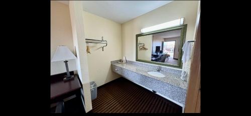 欧克莱尔Scottish Inn & Suites - Eau Claire的一间带水槽和大镜子的浴室