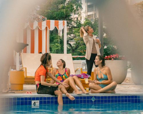檀香山Romer Waikiki at The Ambassador的一群坐在游泳池周围的女人