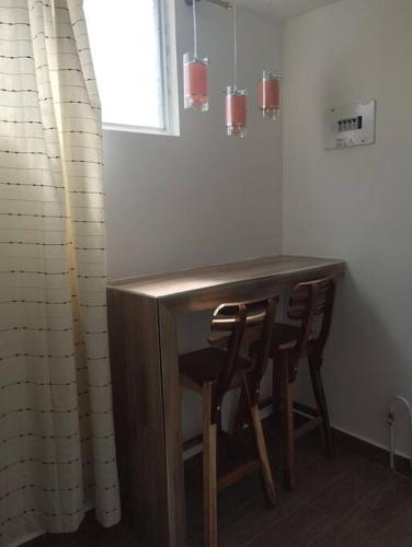 卡利马Aparta studio en el centro的厨房配有木桌和两把椅子