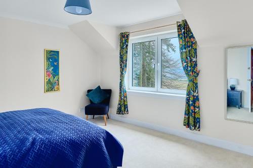 CononbridgeKinkell House B&B的一间卧室设有蓝色的床和2个窗户。