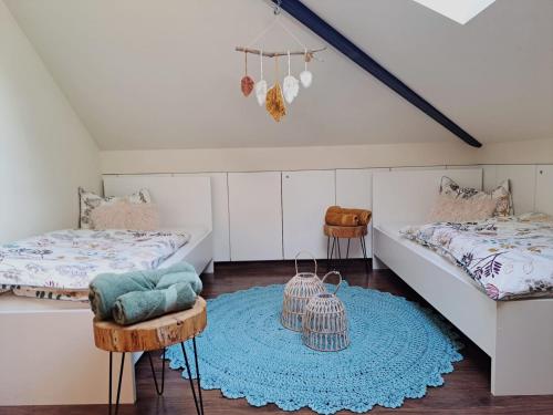 梅拉诺Mansarde Zeder in Privatvilla im Zentrum Merans的一间带两张床的卧室和蓝色地毯