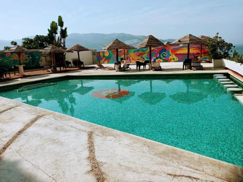 阿卡普尔科Las Torres Gemelas的一个带桌子和遮阳伞的大型蓝色游泳池