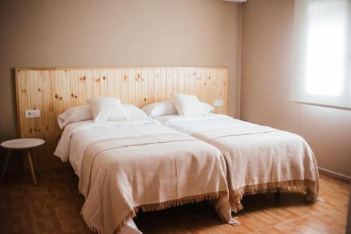 巴达霍斯HOSTAL ENTREOLIVOS的一间卧室配有两张带白色床单的床