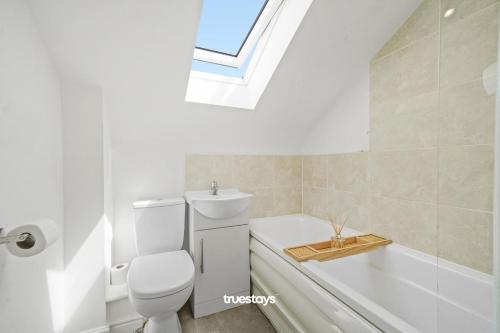 曼彻斯特6 Sarah House by Truestays - 2 Bedroom Apartment - FREE Wifi & Parking的一间带卫生间和浴缸的浴室以及窗户。