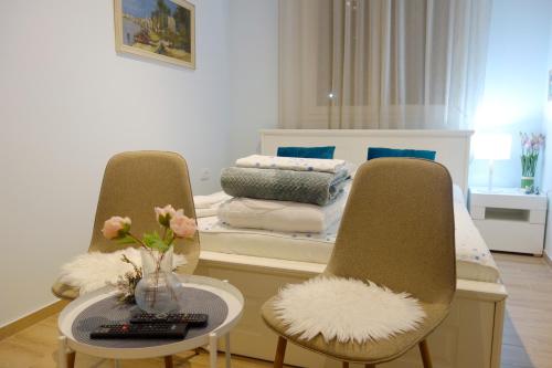 贝尔格莱德Villa Loop Beograd的一间卧室配有一张带两把椅子和一张桌子的床。