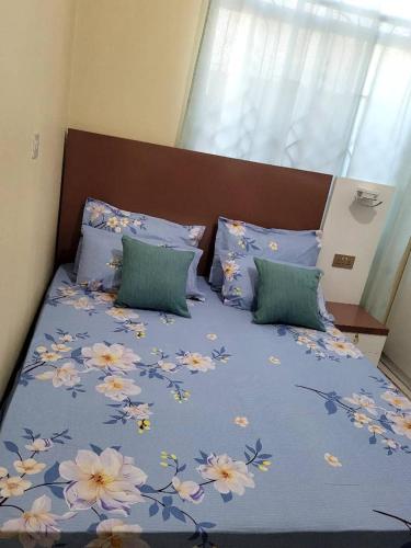 姆贝亚Swahili home-Mbeya CBD的一张床上,床上有鲜花,有蓝色的毯子