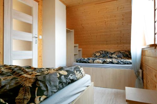 德布吉Domki Rejs的木墙客房的两张床