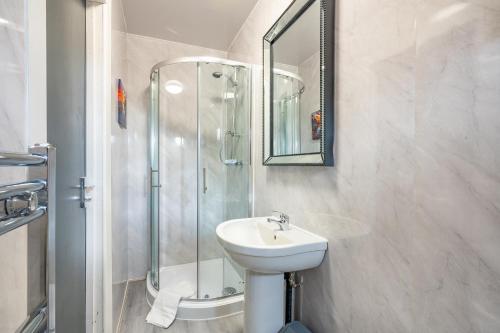 利兹*RC246*For your relaxed & Cosy stay + Free Parking的白色的浴室设有水槽和淋浴。