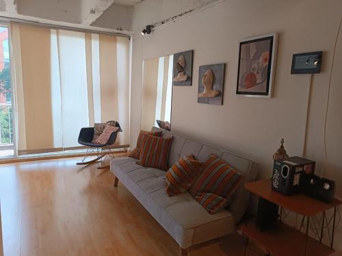 波哥大Apartamento con balcón Javeriana的带沙发的客厅和部分窗户。