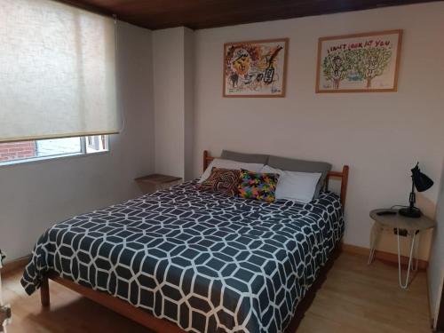 波哥大Apartamento con balcón Javeriana的一间卧室配有一张带蓝色和白色棉被的床