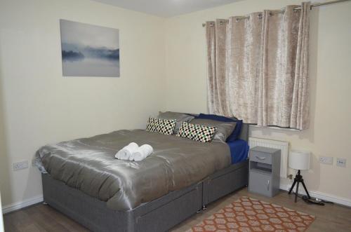 巴尔金Nice and Cosy Flat in London/Ilford/Barking, United Kingdom的一间卧室配有一张床,上面有两条毛巾