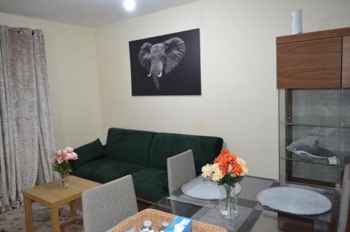 巴尔金Nice and Cosy Flat in London/Ilford/Barking, United Kingdom的客厅配有绿色沙发和桌子
