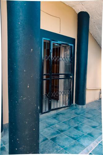 姆巴巴内City Centre Apartment的建筑中带有柱子的蓝色铁门