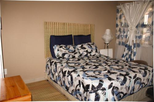 姆巴巴内City Centre Apartment的一间卧室配有一张带黑白色棉被的床