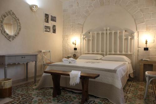 奥斯图尼Masseria Tolla的一间卧室配有一张床、一张桌子和一面镜子