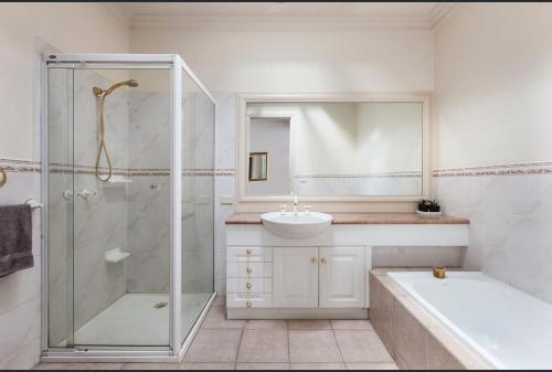 墨尔本Luxurious Townhouse Retreat in Prestigious Brighton的带淋浴、盥洗盆和浴缸的浴室