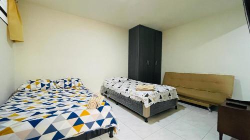 麦德林Aparta-estudio amoblado en Medellin, Campo Valdes的一间卧室配有两张床和一张沙发。