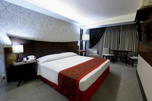 巴雷拉斯Casa dos Belfort的酒店客房设有一张大床和一张桌子。