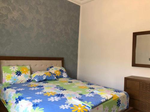 乌姆苏克La villa H的一间卧室配有一张带蓝色棉被的床
