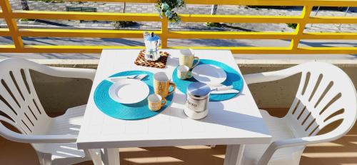 坎波马里诺Il bacio del sole的一张白色的桌子和椅子,上面有一盘食物
