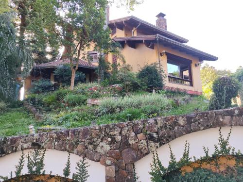 格拉玛多Pousada Oscar Magic Gramado的一座带挡墙和花园的房子