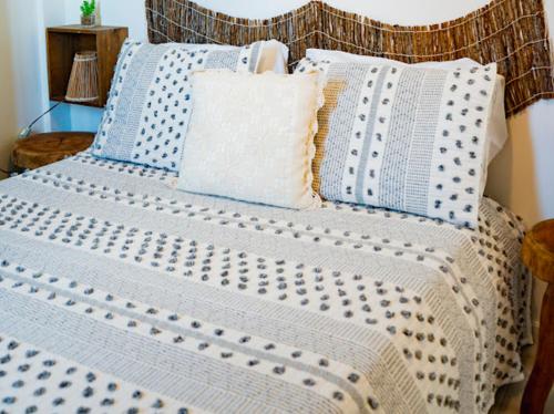 圣米格尔-杜斯米拉格里斯Casa TUA的一张带蓝色和白色床单及枕头的床