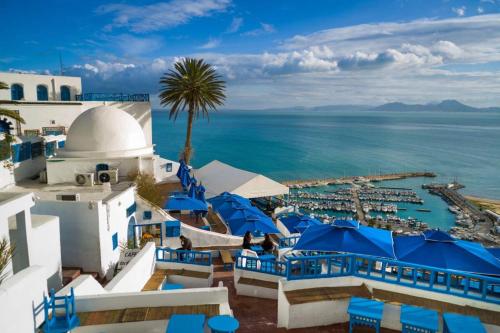 突尼斯باردو الحناية的享有带蓝色椅子的度假胜地和大海的景致