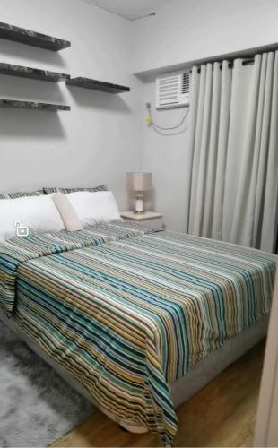 达沃市Modern 2BR Condo with Fiber Net的一间卧室配有一张带彩色毯子的床