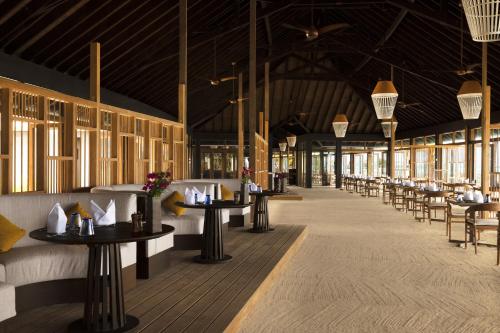 拉薇亚妮环礁Jawakara Islands Maldives的大楼内带桌椅的餐厅