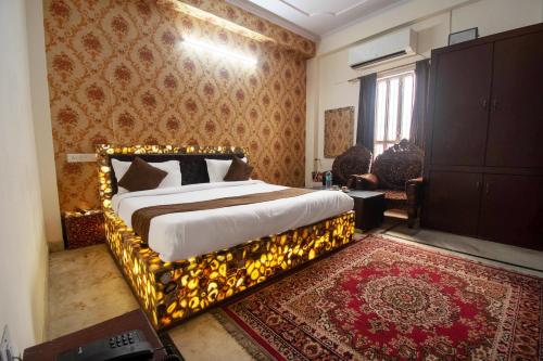 斋浦尔Hotel Marwal的一间卧室配有一张带金色床架的床