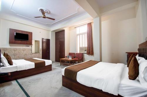 斋浦尔Hotel Marwal的一间酒店客房,设有两张床和电视