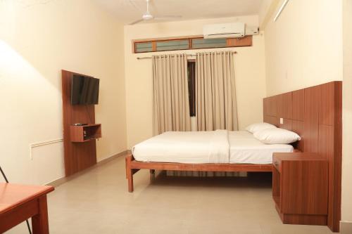 德里久尔Wariyam Heritage的一间卧室配有一张床和一台电视