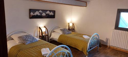 莱德萨阿尔卑斯La Maison de Charlie Les 2 Alpes的客房设有两张床和窗户。