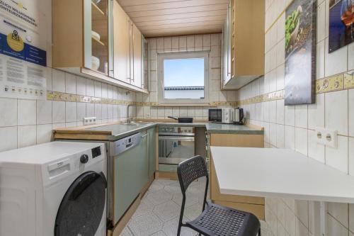 费尔贝特Workers Apartment in Velbert的一间带桌子和洗衣机的小厨房