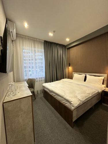阿克套TURAN HOTEL的一间设有大床和窗户的酒店客房
