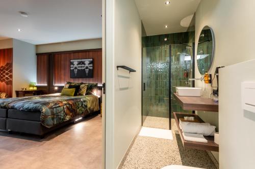NutterTumuli Twente B&B Boutique Hotel的一间卧室配有一张床,浴室设有淋浴。