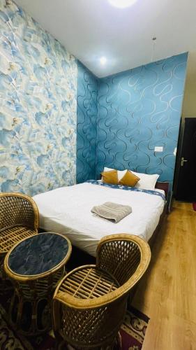 图利凯尔Hotel peace point dhulikhel的一间卧室配有一张带两把椅子和一张桌子的床。