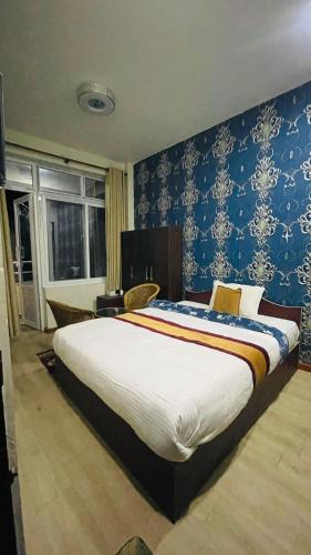 图利凯尔Hotel peace point dhulikhel的一间卧室配有一张带蓝色壁纸的大床