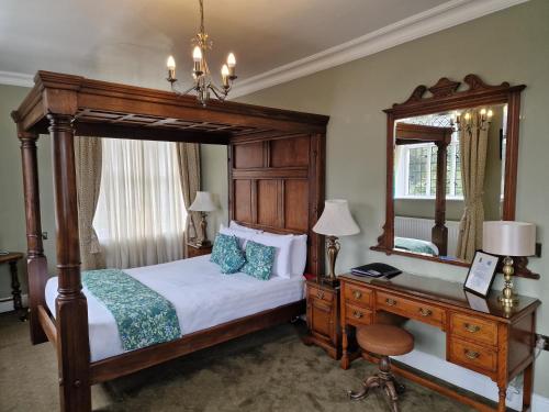 普利斯提恩The Radnorshire Arms Hotel的一间卧室配有一张床、一张书桌和一面镜子