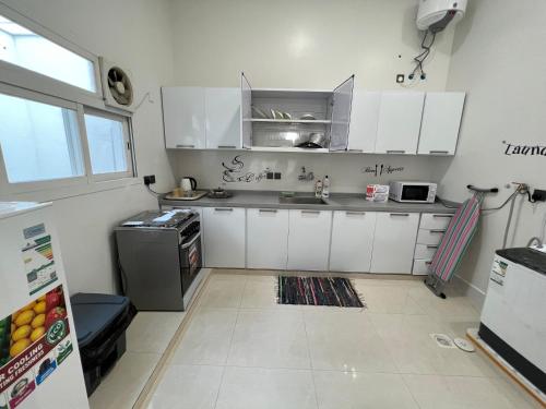 艾卜哈تراحيب ابها - tarahib abha的厨房配有白色橱柜和冰箱。