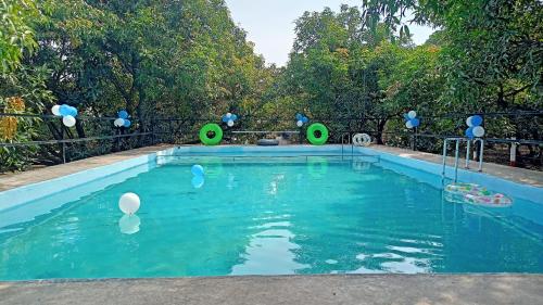 萨三吉尔Renewed Jadeshwar Farm Resort的水中一个有白色和蓝色气球的游泳池
