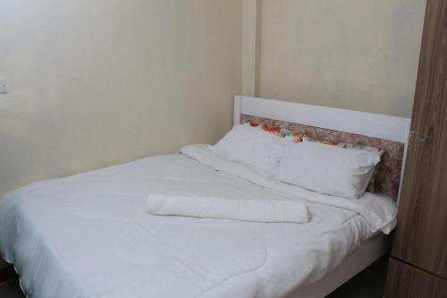 KiganjoChaka Homes的一张白色的床,上面有两条毛巾