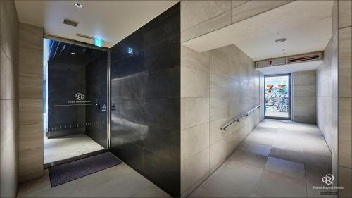 东京Daiwa Roynet Hotel Nishi-Shinjuku PREMIER的大楼内带步入式淋浴间的走廊