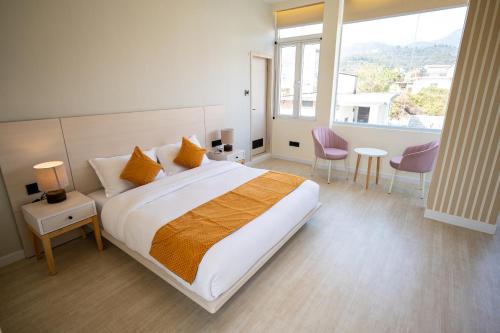 康格拉Luxury 3BHK Villa in Dharamshala with Jacuzzi的一间卧室设有一张大床和一个大窗户